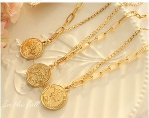 Gros plan du collier de pièces plaqué or avec portrait de reine et chaîne trombone
