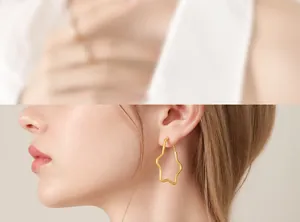 Close-up of stylish 18K gold plated irregular star earrings worn by a fashion model