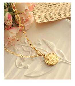 Détail du collier à double chaîne dorée avec pendentif pièce Elizabeth II et gravure de 1990