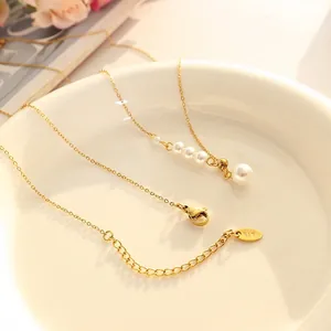 Elegant 18K gold plated necklace with graduated faux pearls on white ceramic plate