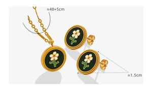 Close-up of daisy jewelry set with black enamel flower necklace and stud earrings