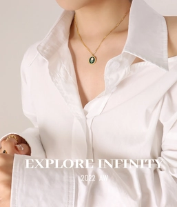 Detail view of a vintage gold floral necklace with a green enamel daisy pendant
