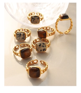 Detail view of vintage chain rings with square tiger eye and spotted natural stones