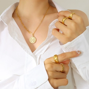 Parure collier avec pièce couronne et quatre bagues texturées sur chemise blanche chic