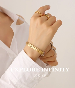 Nahaufnahme eines goldenen Gliederarmbands im Uhrenstil mit polierten Kettengliedern