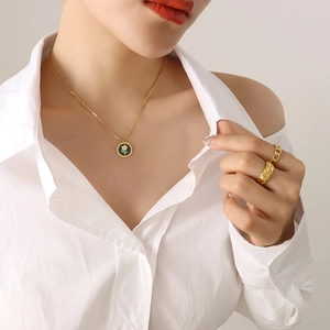 Golden flower pendant necklace with quilted and chain link rings on a model