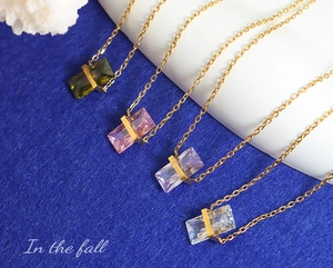 Détail de quatre colliers à pendentifs géométriques colorés avec chaînes dorées
