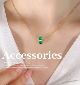 Gros plan d'une chaîne dorée élégante avec un pendentif rectangle en pierre verte émeraude