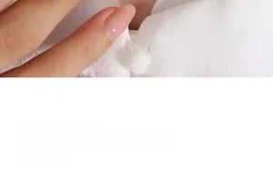 Détail de la texture du tissu blanc et des boutons perlés ronds sur une robe