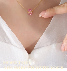 Gros plan d'un élégant collier en or avec un pendentif en pierre rose rectangulaire