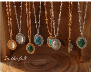 Détail de pendentifs vintage ovales en turquoise et œil-de-chat sur chaînes dorées et argentées
