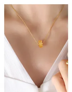 Détail macro d'un pendentif en pierre jaune taille émeraude sur une fine chaîne dorée