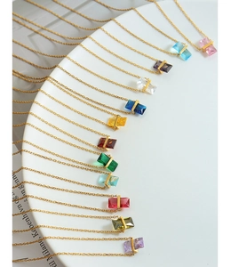 Macro détaillée de 12 pendentifs en cristal coloré sur une chaîne dorée délicate et fine