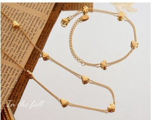 Detailed macro shot of 18K gold plated heart pendant necklace and bracelet jewelry set