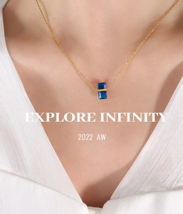 Gros plan d'un pendentif en cristal bleu avec bande dorée sur une chaîne fine