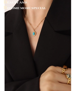 Détail d'un collier bohème doré avec turquoise ovale et bagues vintage serties de pierres