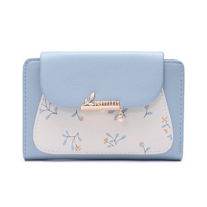 Detail of light blue faux leather wallet featuring floral prints and gold leaf clasp