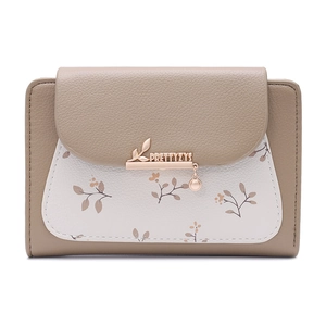 Detailed view of women's floral wallet with gold metal logo and brown leather grain