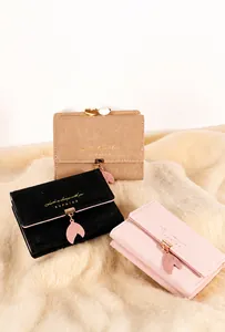 Close-up of minimalist bifold wallets with leaf pendants and multiple card slots