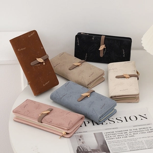 Close-up of matte leather wallets with leaf pattern and metallic leaf-shaped pendants
