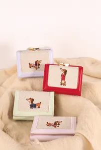 Close-up of PU leather wallets with cute dachshund embroidery and heart metal clasps