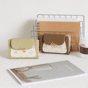 Detail of floral printed PU leather wallet with elegant gold leaf metal buckle