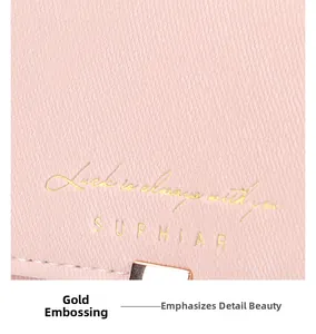 Detail der rosa Blatt-Geldbörse mit Goldprägung und strukturierter Leder-Oberfläche