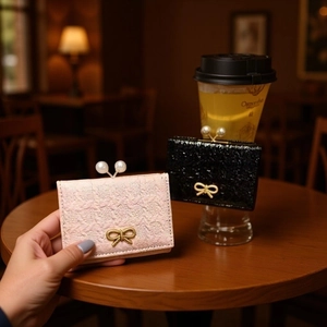 Mini pearl bow wallets in pink tweed and black glitter texture with golden accents