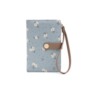 Dettaglio dell'organizer da viaggio in similpelle blu-grigio con stampa floreale e fibbia
