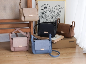 Detail of trendy color-block crossbody bags in beige, black, pink, blue, and brown