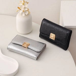 Detailed view of silver and black textured leather wallets with golden square metal buckles