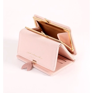 Close-up of pink tri-fold wallet with gold metal leaf buckle and interior card slots