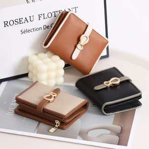 Close-up of three minimalist leather wallets with pebble texture and metal buckles