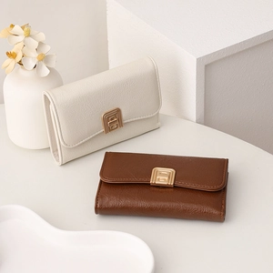 Detail of leather wallets with minimalist golden metal push-lock clasp and lychee texture
