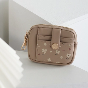 Detailed view of khaki leather wallet featuring floral card slots and leaf metal charm