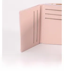 Gros plan des fentes pour cartes et coutures de précision du portefeuille rose