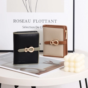 Close-up of minimalist bifold wallets with unique gold metal buckle and zipper detail
