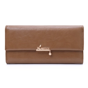 Close-up of brown leather long wallet with golden leaf and pearl pendant detail
