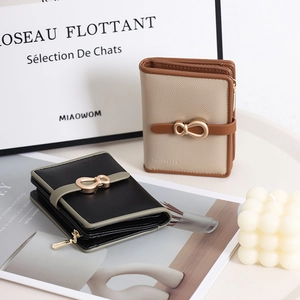Detailed macro view of short tri-fold faux leather wallets with elegant metal bow buckle