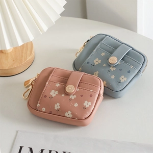 Close-up of floral print mini wallets in pink and blue with premium metal hardware