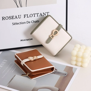 Detail of elegant PU leather wallets with gold metal bow buckle and side zipper pocket