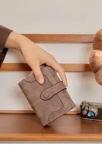 Detailed view of women's vintage brown soft leather wallet with stitching and button closure