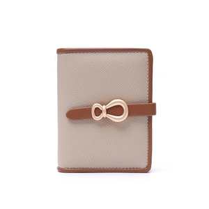 Close-up of beige and brown contrast PU leather wallet with golden knot metal buckle