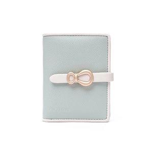 Detail of mint green textured faux leather wallet featuring a gold bow buckle clasp