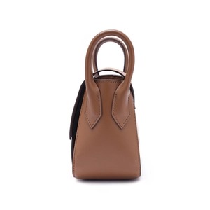 Detail view of the brown leather handbag's side profile with reinforced stitching