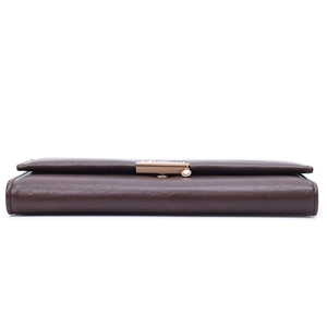 Detail view of the brown leather long wallet's side thickness and golden metal clasp