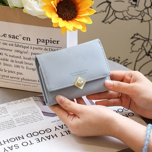 Gros plan du petit portefeuille trifold en similicuir bleu clair avec boucle cœur en métal