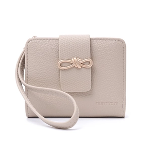 Detail of cream short wallet with lychee grain leather and golden bow metal clasp