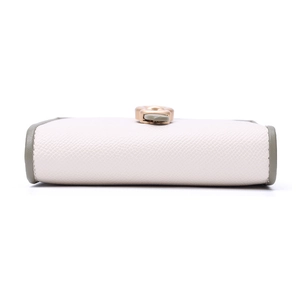 Detailed side view of the white pebble leather wallet with green trim and gold buckle