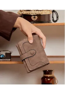 Gros plan d'un portefeuille en daim marron avec coutures blanches sur fond vintage